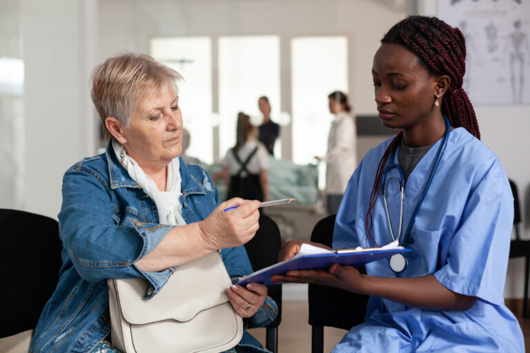 African american nurse explaining sickness treatment to elderly patient